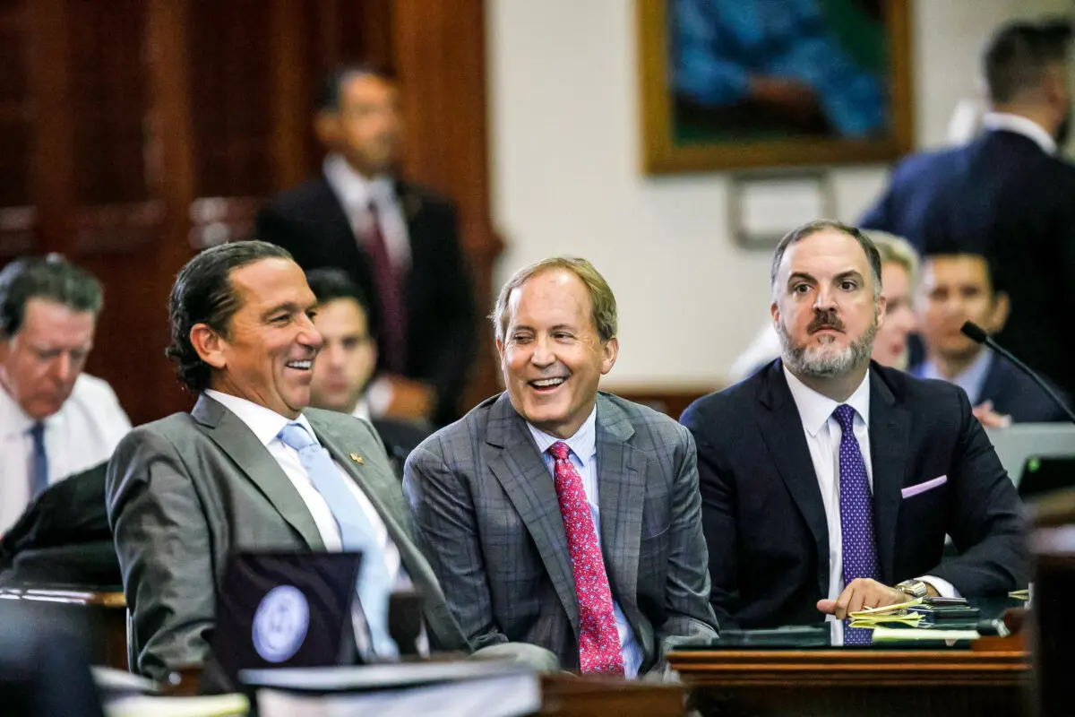 Texas Attorney General Ken Paxton (center ) sits between defense attorneys Tony Buzbee ( left ) and Mitch Little ( right ) before his impeachment trial resumes in the Senate Chamber at the Texas Capitol, in Austin, Texas, on Sept. 15, 2023. ( Sam Owens/The San Antonio Express- News via AP, Pool )