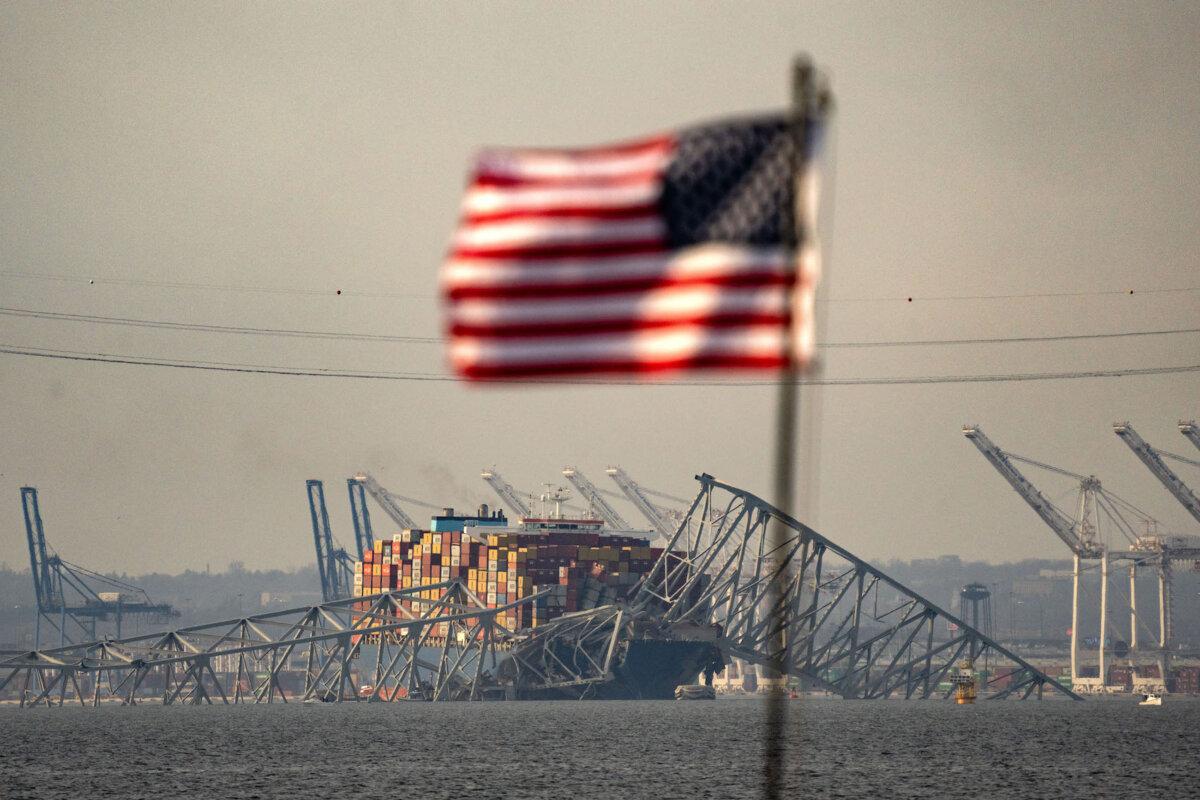 After the Francis Scott Key Bridge broke free in Baltimore, Maryland, on March 26, 2024, a portion of its steel frame was lowered to the top of the container ship Dali. ( Kent Nishimura/AFP via Getty Images )