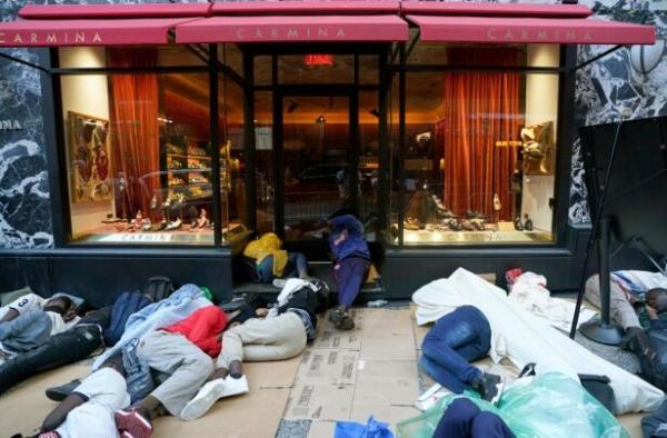 Illegal immigrants wait for placement at the hotel in New York on August 1, 2023, outside the Roosevelt Hotel. ( Timothy A. Clary/AFP via Getty Images )