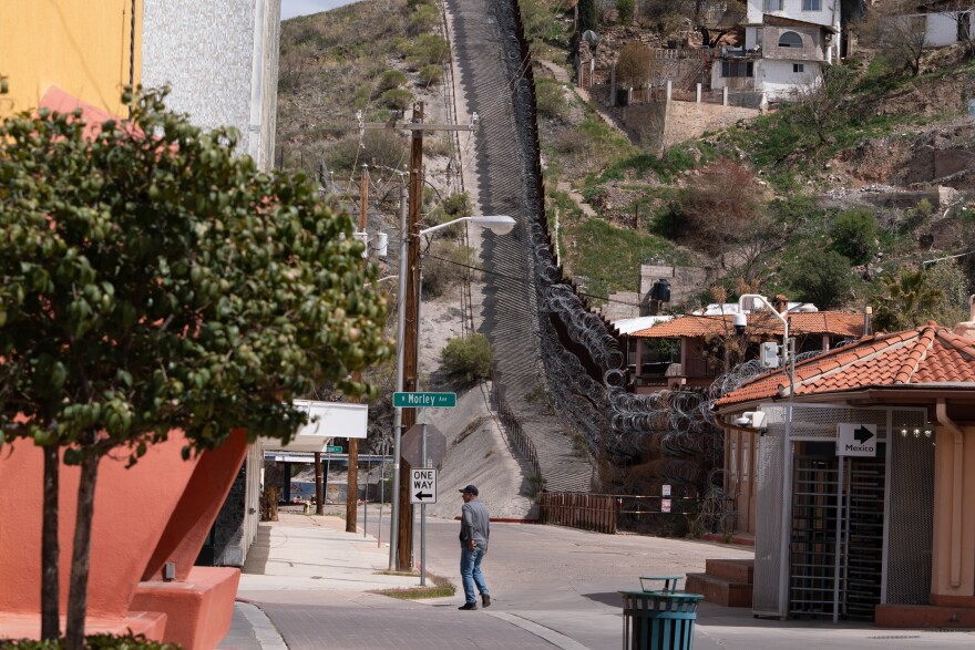 A person crosses the boundary from Mexico to pass by the city of Nogales in Arizona.