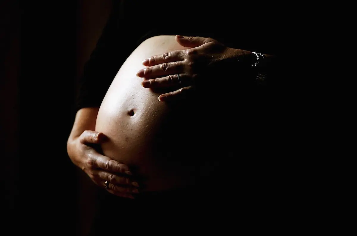 A pregnant woman holds her stomach on June 7, 2006. (Ian Waldie/Getty Images)