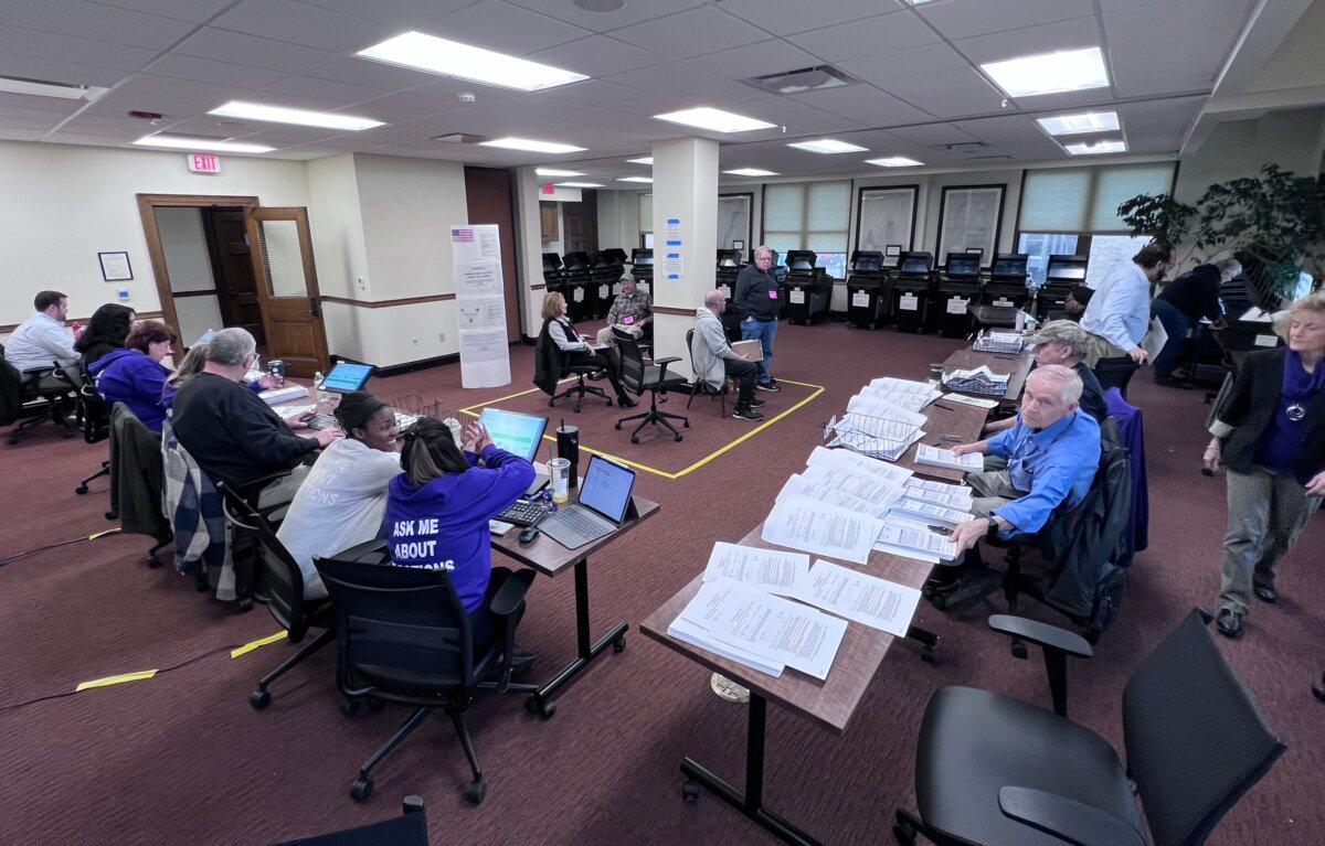 Poll employees count absentee ballots as election spectators look on at City Hall in Racine, Wis., on April 2, 2024. ( Lawrence Wilson/The Epoch Times )