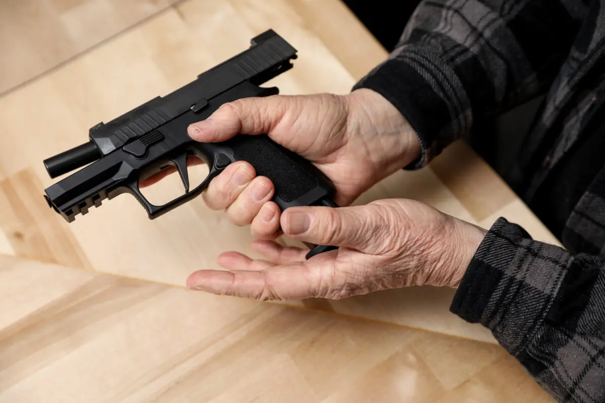 A magazine is loaded into a Sig Sauer P320 compact semi- auto pistol at a gun shop in Richmond, Va., on Jan. 13, 2020. ( Samira Bouaou/The Epoch Times )