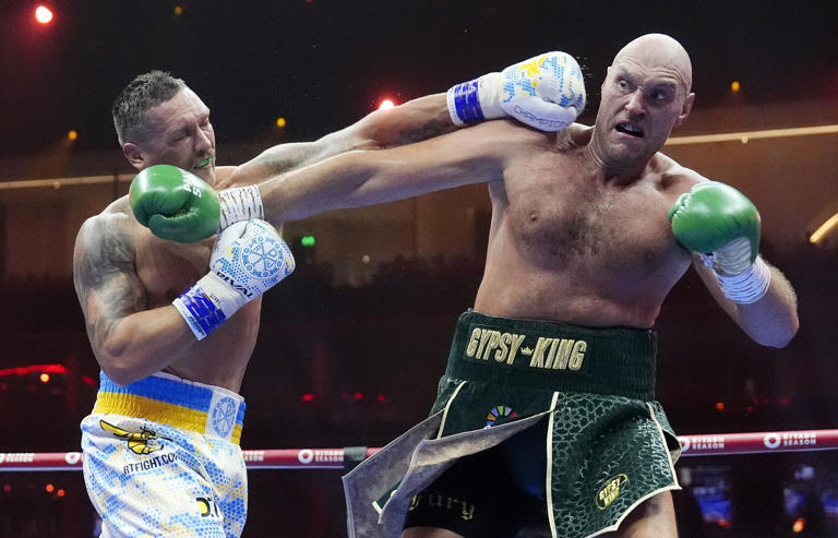 Britain's Tyson Fury, straight, and Ukraine's Oleksandr Usyk trade punches during their unquestioned heavy world championship boxing struggle at the Kingdom Arena in Riyadh, Saudi Arabia, Sunday, May 19, 2024. ( Nick Potts/PA via AP )